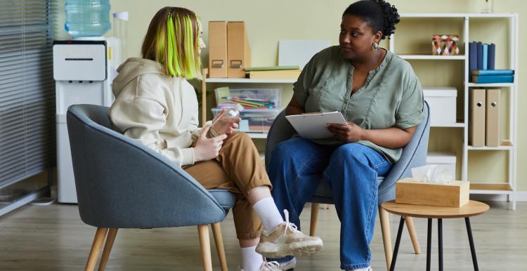 2 women sitting in chairs and talking