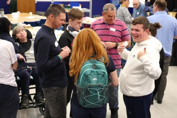 A group of people standing up and talking at an event