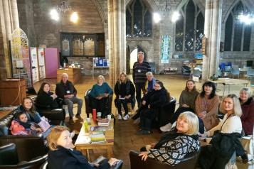 A group of people sitting in a circle in a church setting