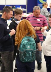 A group of people standing up and talking at an event